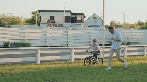 Father Teaching Son Riding Bike