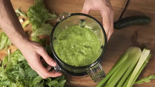 Zu Hause grünen Saft zubereiten Männliche Hände Mischen von Gemüsesmoothie im Glasmixer zu Hause