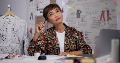 Fashion Designer Drawing Designs in Workplace