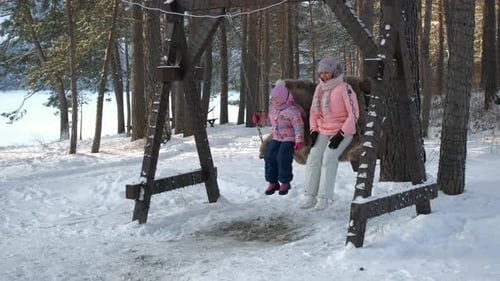 Girl and Woman Enjoying a Winter Swing