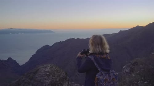 Attractive Mature Woman in Hiking Adventure on a Mountain Top Looking at the Horizon