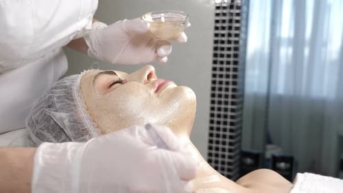 Beautician Applying Facial Mask in Spa