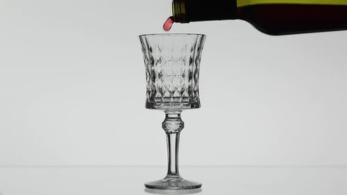 Rose Wine. Red Wine Pour in Wine Glass Over White Background. Slow Motion