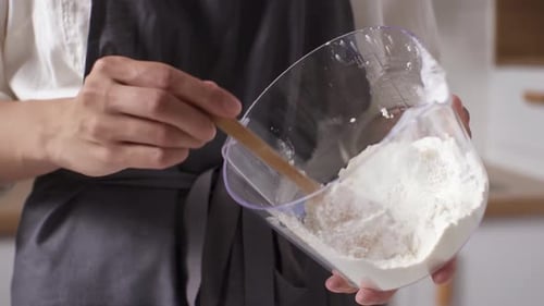 Woman Uses Spoon to Scoop Flour
