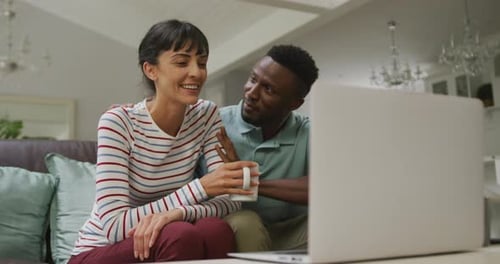 Couple Relaxing on Couch Watching Laptop