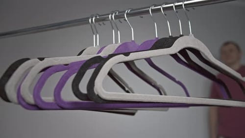 Hangers on Rod, Man Taking Hanger