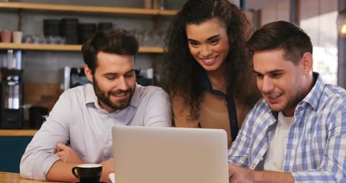 Team Looking at Laptop in Cafe
