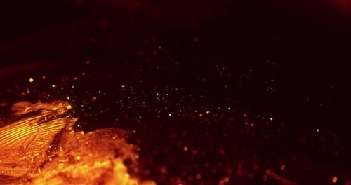 Close Up of Glowing Orange Particles in Dark Liquid