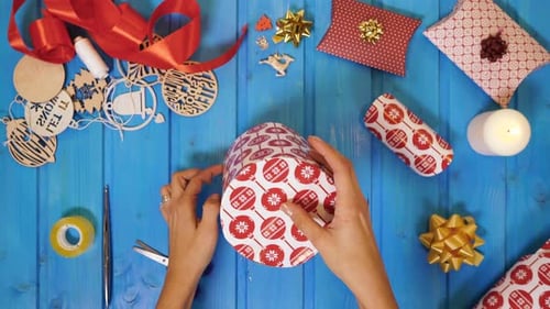 Wrapping Christmas Gift on Wooden Table