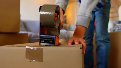 Mid section of boy packing cardboard boxes in a comfortable home 4k