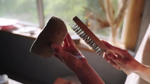 Woman Brushing a Ceramic Bowl in Studio