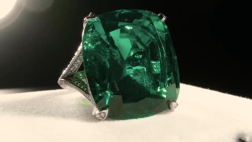 Macro filming of large green emerald stone in jewelry ring. Royal crystals.