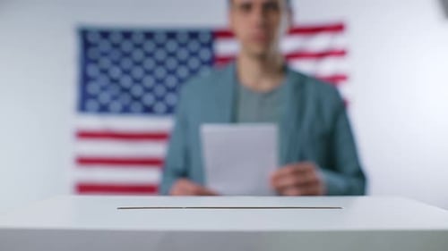 Man Throws a Ballot Into the Ballot Box