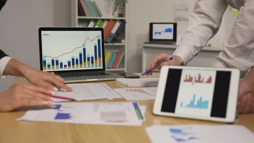 Business Partners Discussing Economic Situation of Company at Meeting in Office