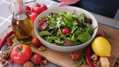 Adding Tomatoes to Salad with Fresh Ingredients