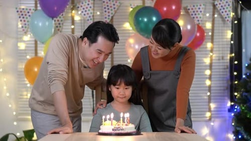 Family Celebrating Daughter's Birthday Together with Cake