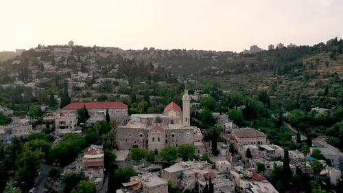 Fly over Muslim mosque in a small village in the middle of the woods, pastoral view, aerial shot, dr