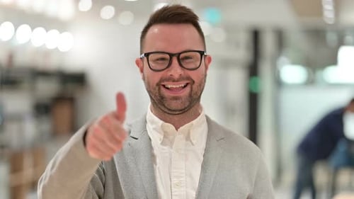 Smiling Man Gives Thumbs Up in Office Setting