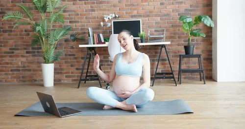 Pregnant Woman Practicing Yoga During Online Class