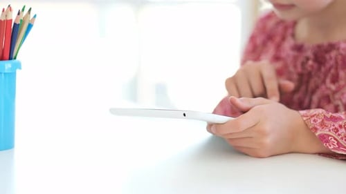Child Using Tablet at Table Indoors