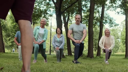 Diverse Adults and Seniors Practicing Lunge Exercise in Park