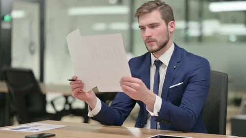 Businessman Reading Documents in Office
