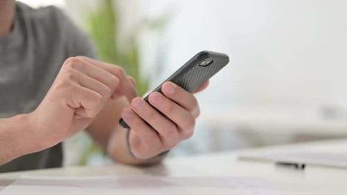 Hands of Young Man Using Smartphone Close Up