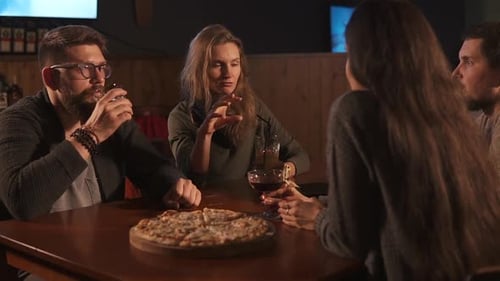 a Group of Friends Having Supper and Drinking in a Cafe Men and Women Chatting