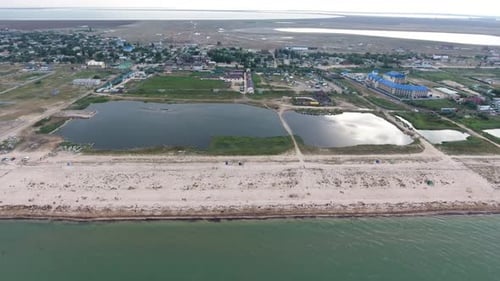 Aerial of Black Sea Sand Spit with Lines of Lounges, Hotels, Houses and Greenery