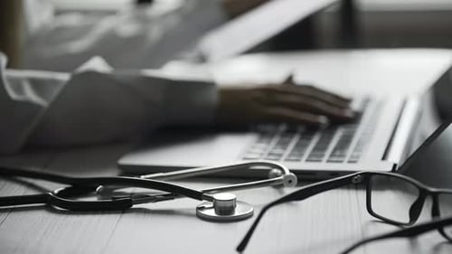 Close Up of a Doctor is Working and Typing on Laptop in a Clinic