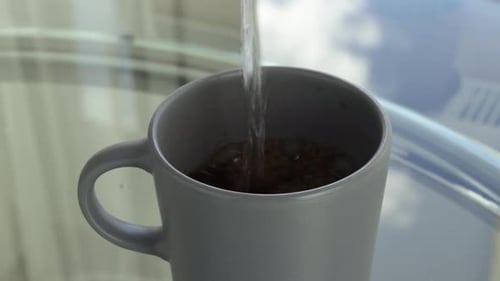 Water Pouring Into Coffee Mug Close Up