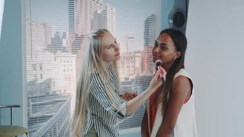 Make-Up Artist Applying Makeup to a Seated Woman