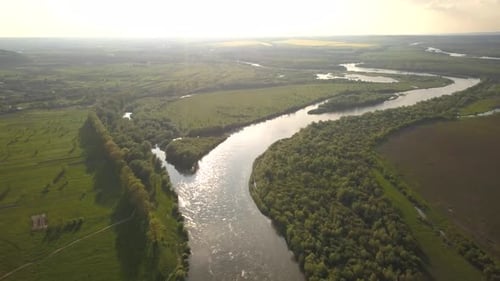 Vue aérienne d'une grande rivière aux berges verdoyantes.