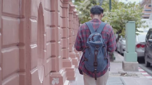 Young Adult Walking in a City with Backpack