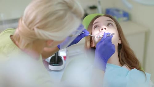 Teeth Treatment Process in Dentist Office. Blonde Dentist Working with Patient