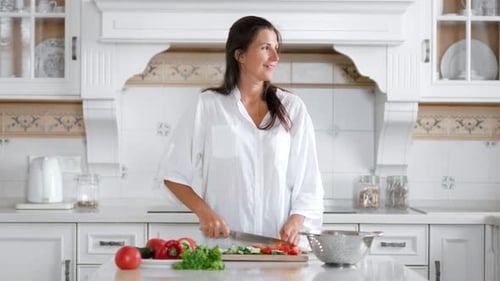 Woman Chopping Vegetables in Bright Modern Kitchen