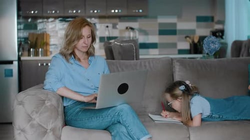Woman Work with Computer Laptop While Her Daughter in Painting on Couch Rbbro