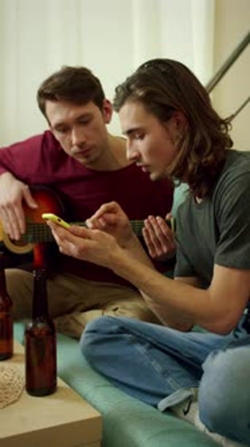 Two Young Adults Relaxing with Guitar and Phone