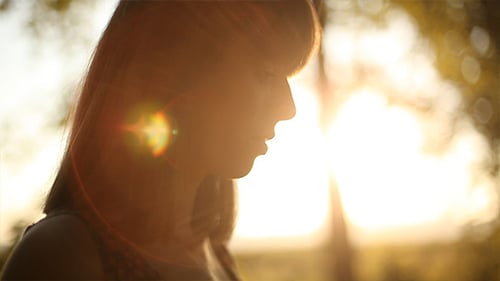 Pensive Woman Bathed in Golden Sunlight