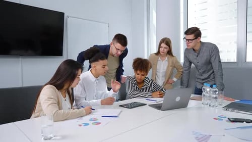 Diverse Team Collaborating on Tablet in Modern Office