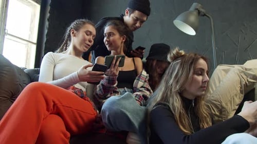 Adolescentes compartilham vídeos em aplicativos de mídia social sentados em um sofá