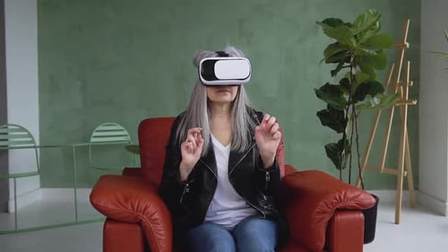 Woman Uses VR Headset in a Red Chair