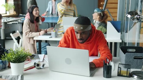 Excited Man Cheers Success with Coworkers in Office