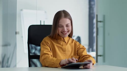Young Positive Woman Manager Working on Digital Tablet Chatting with Client or Making Online