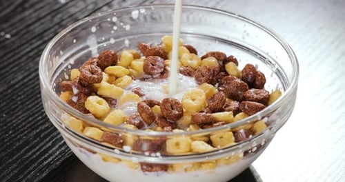 Milk Pouring into Cereal Breakfast Bowl Close-Up