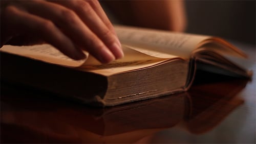 Hands Turn Pages of Old Book Close Up