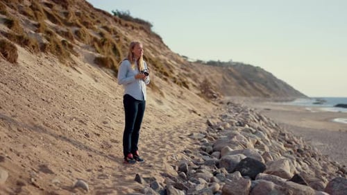 Photographer Using Slr Camera On Beach