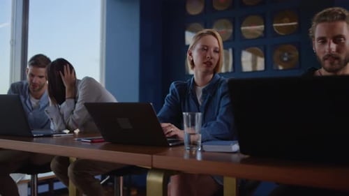 Focused Workers Talking in Business Center. People Working on Laptops in Office