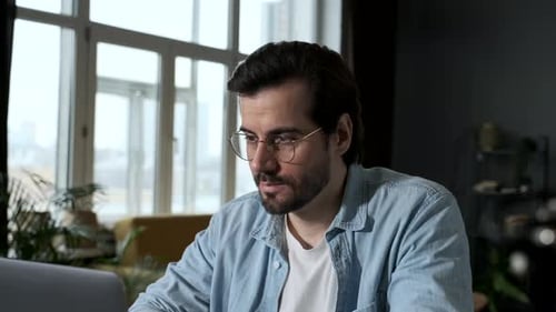 Man Working on Laptop Indoors During Daytime