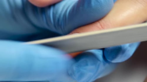 Manicure sägt den Nagel des Kunden mit einer Nagelfeile. Nahaufnahme